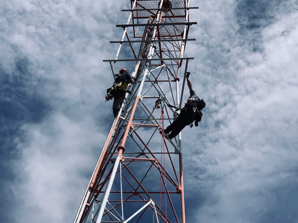 Engineers climb a tower structure
