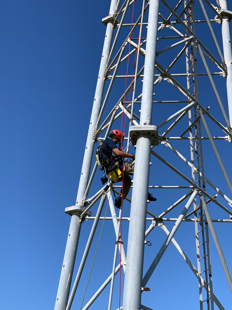 Engineers climb a tower structure