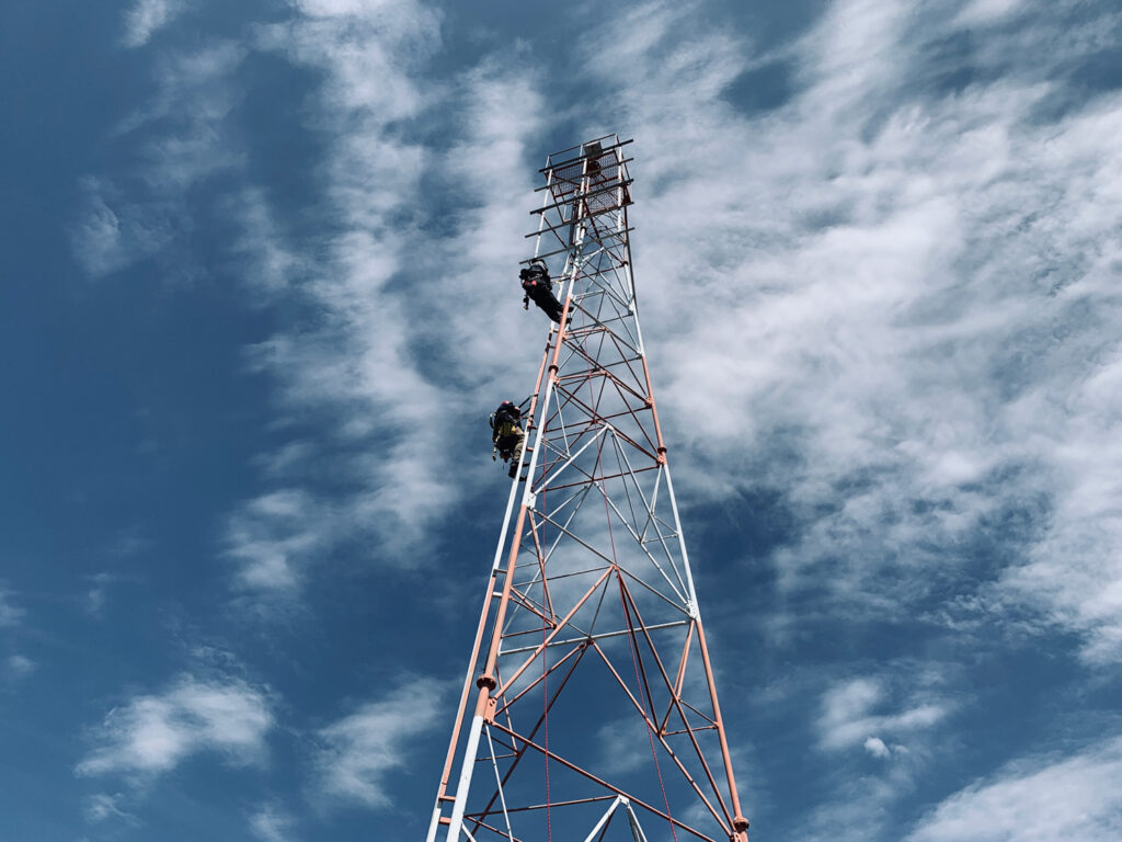 Engineers climb a tower structure